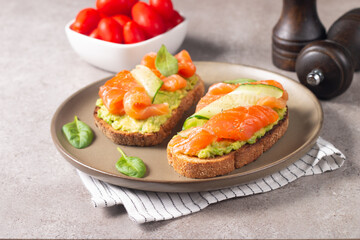Two tasty open salmon sandwiches with avocado and cucumber. Morning healthy breakfast. Top view.
