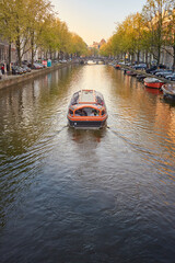 Fototapeta na wymiar a boat cruising in the canal at Amsterdam 