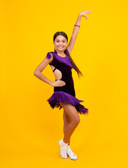 Teen girl dancing in ballroom dress, isolated on yellow background.