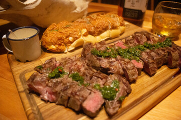 Carne fatiada com pão italiano ao lado em ambiente texano
