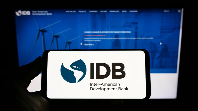 Stuttgart, Germany - 07-09-2022: Person holding smartphone with logo of Inter-American Development Bank (IADB) on screen in front of website. Focus on phone display.
