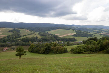 Flowing hills and farmland under clouded sky