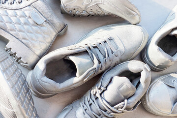 Boots and sneakers in silver color, abstract shoe background