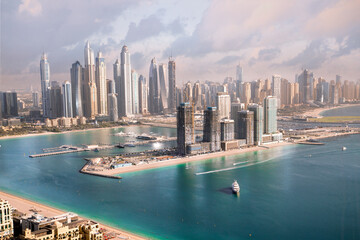 Dubai Marina skyscrapers view at sunset with boats and yachts in the Persian gulf waters. Dubai,...
