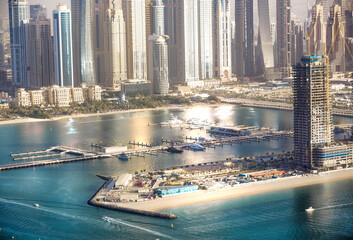 Fototapeta premium Dubai, UAE. Dubai Marina yachts pier view at sunset with beautiful golden reflection in the water