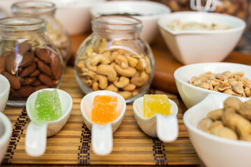 Rustic wood table filled with a large assortment of nuts like pistachios, hazelnut, pine nut, almonds, pumpkin seeds, sunflower seeds, peanuts, cashew and walnuts