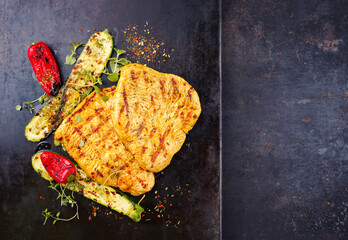 Traditional barbecue turkey escalope filets in curry marinade with grilled vegetable served as top...