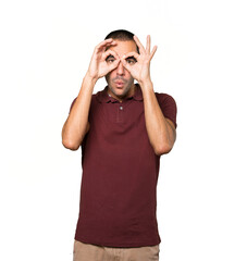 Fototapeta premium Amazed young man using his hands like a binoculars