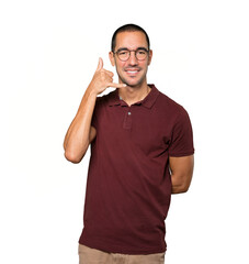 Happy young man making a gesture of calling with the hand