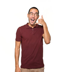 Amazed young man making a gesture of calling with the hand