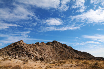 Fototapeta na wymiar terrain rock desert mountain landscape blue sky hiking trail area clouds weather overcast adventure