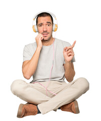 Young man in sitting position with a worry gesture