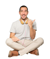 Young man in sitting position with a finger pointing gesture