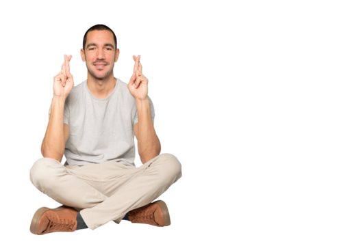 Happy young man doing a crossed fingers gesture