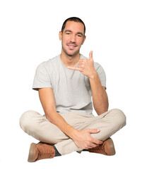 Happy young man making a gesture of calling with the hand