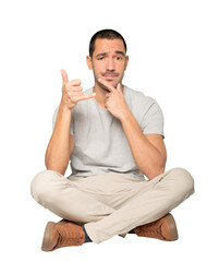 Hesitant young man making a gesture of calling with the hand