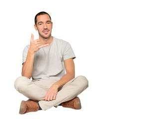 Happy young man making a gesture of calling with the hand