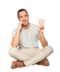 Young man making a number three gesture