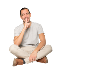 Happy young man asking for silence gesturing with his finger