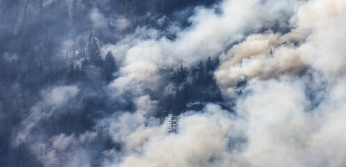 BC Forest Fire and Smoke over the mountain near Hope during a hot sunny summer day. British Columbia, Canada. Wildfire natural disaster