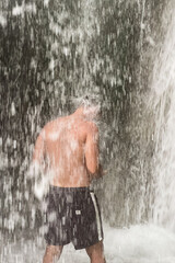 Fototapeta na wymiar A man standing under a waterfall in Morocco