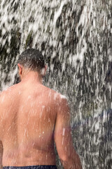 A man standing under a waterfall in Morocco
