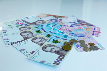 Stack of various Ukrainian hryvnia banknotes. Ukrainian money banknotes and coins isolated at white background. Side view.