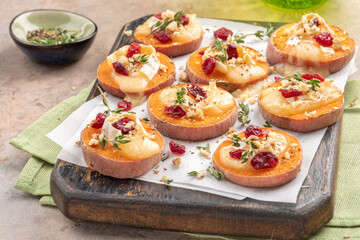 Baked Sweet Potato Rounds topped with brie cheese, cranberry and Walnut. Thanksgiving appetizer...