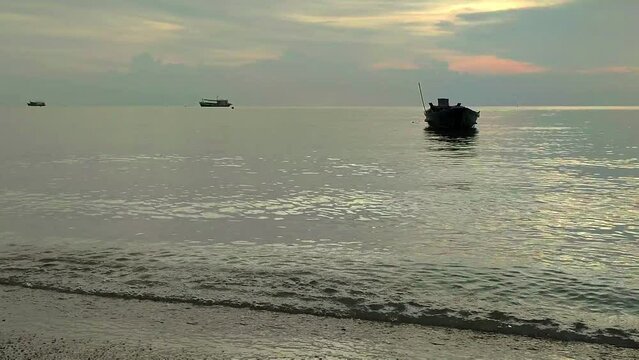 Barcos atracados en playa calma al atardecer