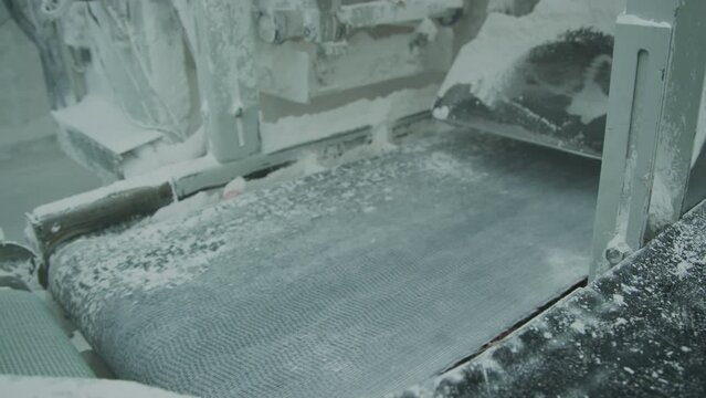 Bags with marble aggregate on conveyor at natural stone processing factory