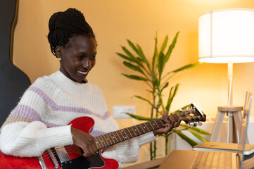 Young woman giving or receiving electric guitar classes online