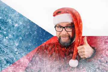 bearded citizen of the Czech Republic in Santa hat and glasses positively gives thumb up everything is fine on snowy background in frost, gas crisis in Europe