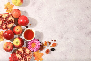 Autumn banner with honey, apples, pomegranates, flowers, dried fruits on a warm vintage background,...