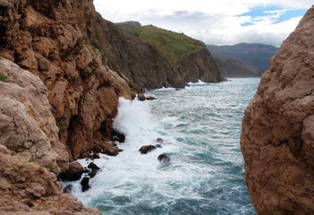 Fototapeta na wymiar Beautiful seascape with turquoise storming water and high cliffs. Great design for any purposes. Beautiful summer landscape. Natural background. Copy space.