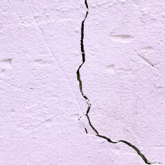 Pink plastered stucco wall with crack abstract background for graphic designers. There are no people or trademarks in the shot.
