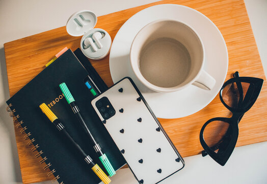 Empty Cup On Wooden Tray With Phone, Glasses, Notebook And Headphones. Autumn Flatlay.