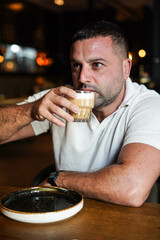 Hombre de mediana edad sentado en un bar para desayunar