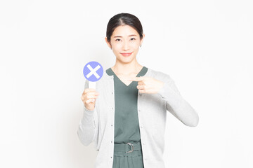 NGのプレートを持っている女性