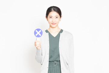 NGのプレートを持っている女性