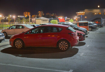 Fototapeta na wymiar Cars at night in an illuminated parking lot