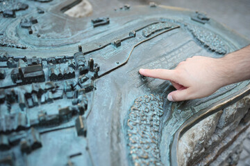 Hand points on city map with braille letters blind alphabet braille