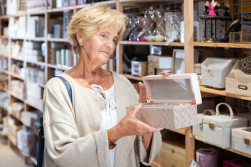 Mature woman customer looking for storage box for accessories at household store