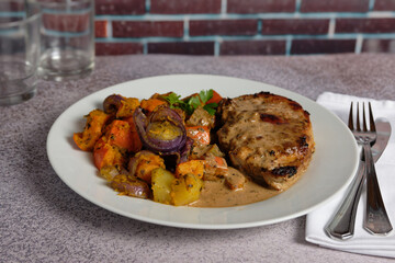 Braised Hokkaido squash with crispy fried pork chop served on a plate.