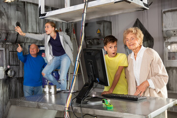 Young boy and girl resolving riddles with their grandfather and grandmother in escape room.