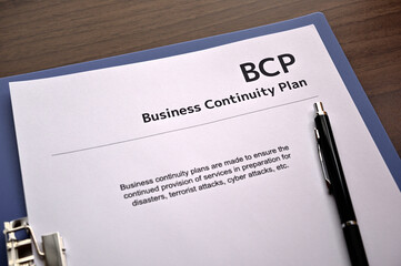 There is dummy documents that created for the photo shoot on the desk about Business Continuity Plan.