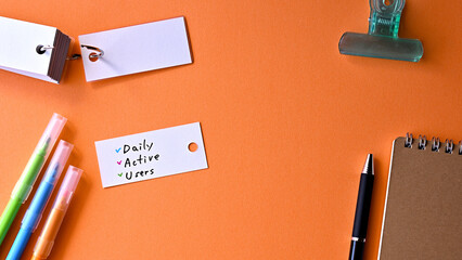 There is word card with the word Daily Active Users on the desk.
