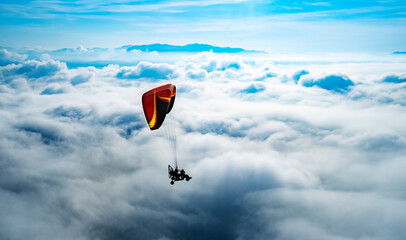 Challenge and freedom concept. red para motor on high blue sky and puffy white cloud. Extreme...