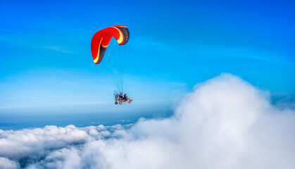 Challenge and freedom concept. red para motor on high blue sky and puffy white cloud. Extreme...