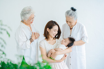 赤ちゃんを抱っこするシニア女性とお母さん