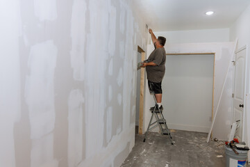 Hand worker trowels putty on drywall finishing putty with a spatula the putty